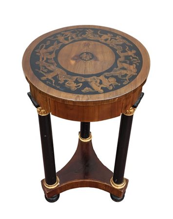Tavolino tondo lastronato in legni vari con tre colonne ebanizzate e capitelli