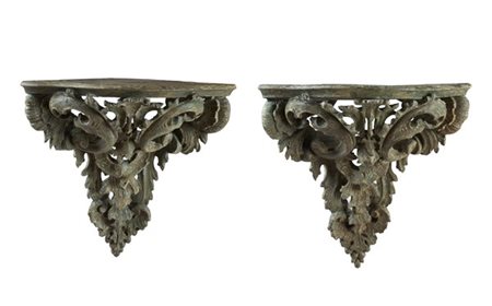 Coppia di mensole angolari in legno intagliato, traforato e dipinto a volute e