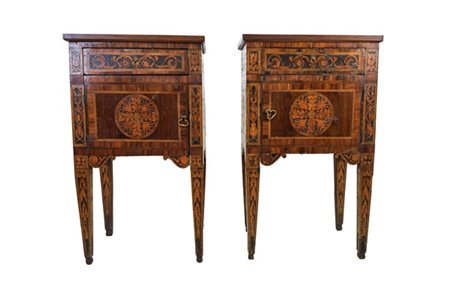 Coppia di comodini lastronati, filettati e intarsiati in legni vari ad un'anta