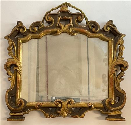 Cornice da centro in legno intagliato, traforato e dorato di forma sagomata. Se