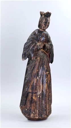 A roughly carved hanging statue of a saint, with remains of polychrome,...