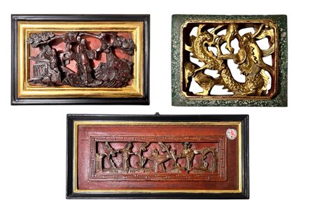 Lotto di tre pannelli in legno intagliato e lumeggiato in oro