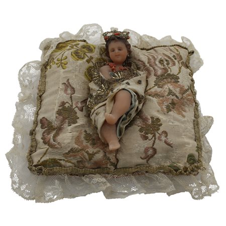 Bambinello Cera policroma con vesti ricamate in corallo. Sicilia. Secolo XIX....