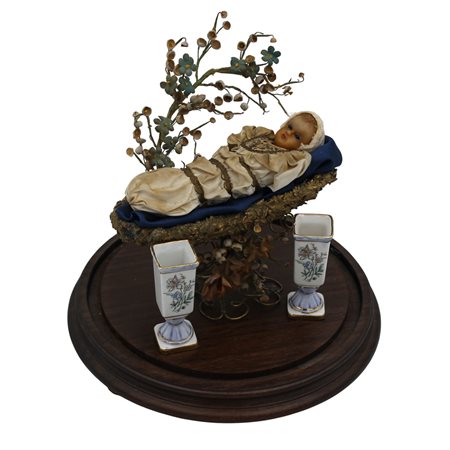 Bambinello Cera policroma in teca con campana in vetro. Sicilia. Secolo XX....