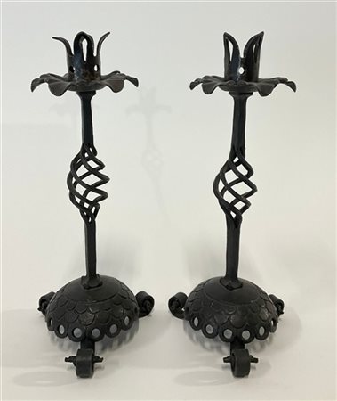 Coppia di candelieri in ferro forgiato e traforato su base tripode. Milano, ann