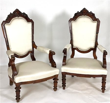 Coppia di poltrone in noce, schienale con cimasa intagliata a fiori. Gambe ante