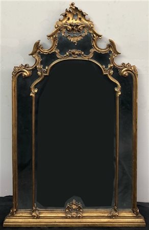 Caminiera a doppio ordine in legno intagliato e dorato a volute con motivi flor