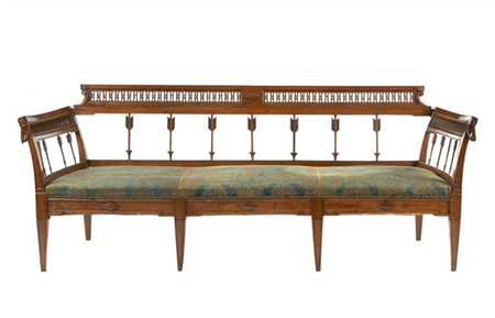 Divano in noce intagliato, schienale a giorno con elementi in forma di dardo e