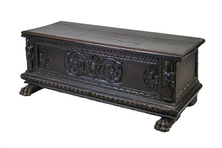 Antica cassapanca in legno a tinta scura con fronte intagliato a motivi floreal