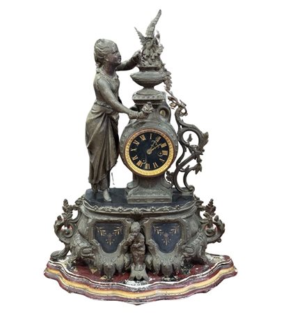 Orologio in metallo antimonio, periodo XIX/XX secolo. Dimensioni: h56x40 cm....