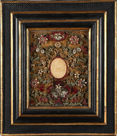 Agnus Dei in cera con cornice in legno ebanizzato, intagliato e dorato,...