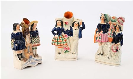 Due spills vases ed un gruppo con figure di villani in ceramica policroma,...