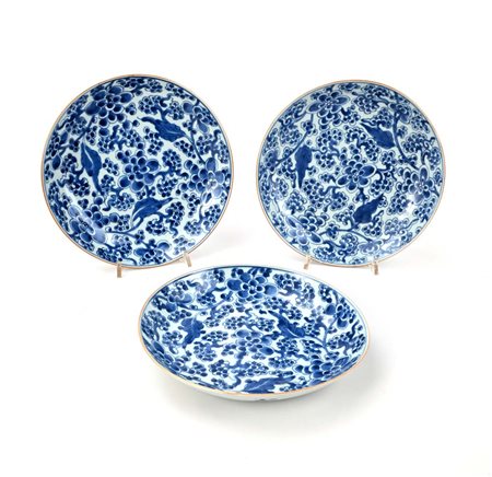 Tre piatti in porcellana bianca e blu con fitta decorazione floreale, Cina,...