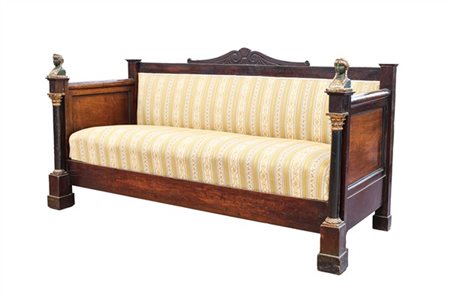 Divano in legni vari con montanti a colonna ebanizzata su plinto e cimatura a b