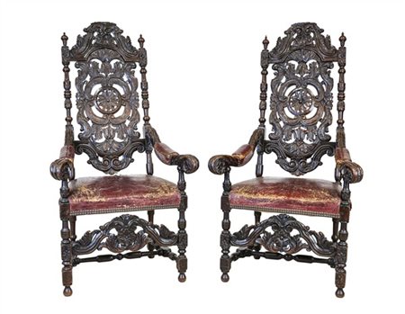 Coppia di seggioloni in rovere intagliato, schienale traforato a motivi vegetal