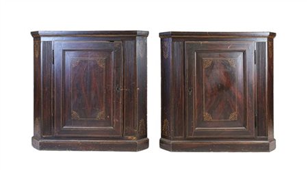 Coppia di cantonali in legno dipinto ad un'anta pannellata e lesene baccellate.