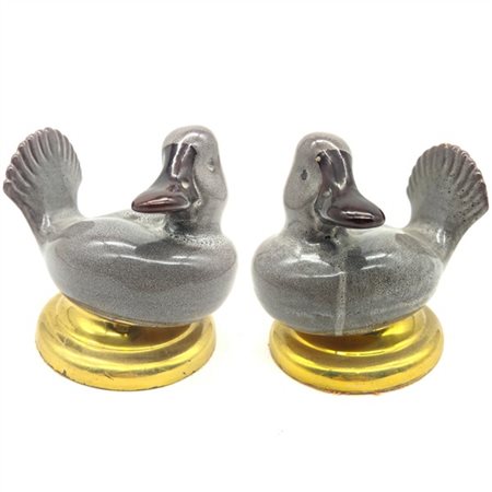 Manifattura del secolo XX. Coppia di anatre in ceramica spugnata manganese (cm