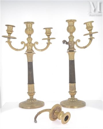 Paire de candélabres à deux bras de lumière En bronze patiné et doré. Le fût...