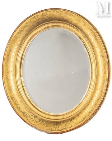 Miroir ovale En bois mouluré et stuc doré, à décor de feuillages en nuances...