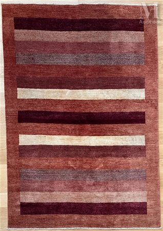 Tapis en laine A décor de nuances d'ocres en bandes polychromes sur fond uni....