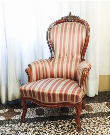POLTRONA IN NOCE metà del XIX secolo schienale intagliato, gambe mosse,...