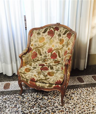 POLTRONA IN NOCE schienale sagomato, gambe mosse, imbottita e rivestita in...