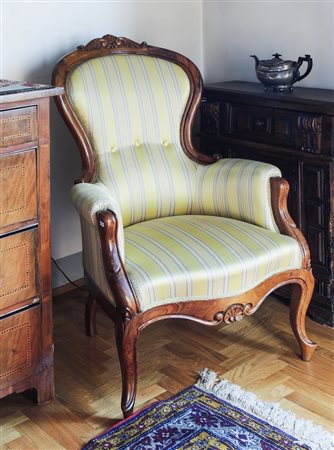 POLTRONA IN NOCE seconda metà del XIX secolo schienale con cimasa intagliata,...