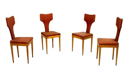 PRODUZIONE ITALIANA Quattro sedie in legno di rovere e skai imbottito. Anni...