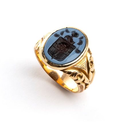 Anello in oro con stemma araldico su agata in oro giallo, montatura decorata...