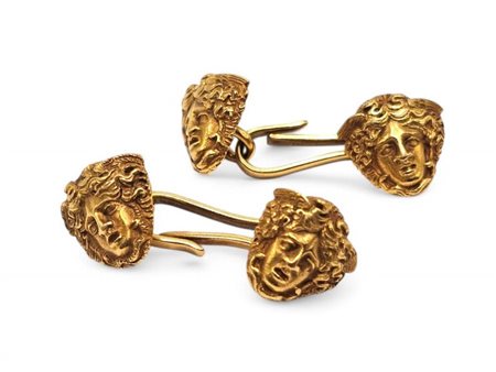 Gemelli in oro decorati a forma di teste di figure mitologiche. Dimensioni:...