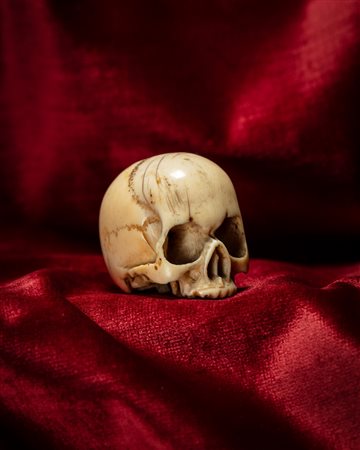 MEMENTO MORI RAFFIGURANTE TESCHIO IN AVORIO INTAGLIATO E TRAFORATO. NORD EUROPA, INIZIO SECOLO XX