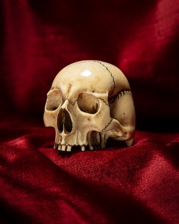 MEMENTO MORI RAFFIGURANTE TESCHIO IN AVORIO INTAGLIATO E TRAFORATO. NORD EUROPA, INIZIO SECOLO XX