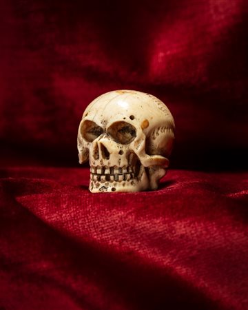 MEMENTO MORI RAFFIGURANTE TESCHIO IN AVORIO INTAGLIATO E TRAFORATO. NORD EUROPA, INIZIO SECOLO XX