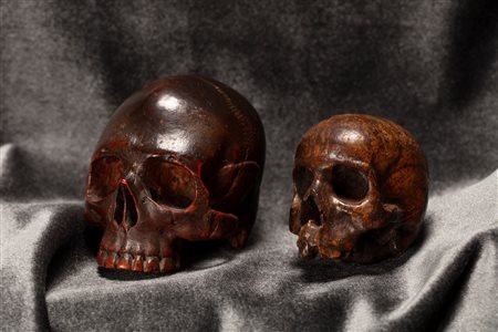 Due memento mori a guisa di teschio in legno finemente intagliato. Secolo XIX