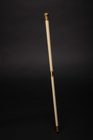 Bacchetta da direttore d'orchestra in avorio con pomello e puntale in metallo dorato finemente sbalzato e cesellato, fascetta centrale con medaglione. Secolo XIX