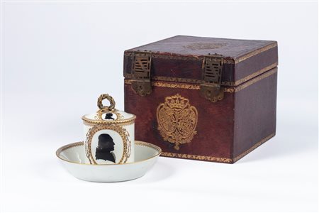 Tazza con coperchio e piattino in porcellana profilata in oro, entro cofanetto rivestito in cuoio  stemmato. Manifattura di Meissen, periodo Marcolini, fine secolo XVIII/inizio secolo XIX