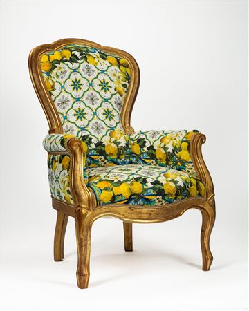 Poltrona di forma mossa in legno intagliato e dorato con braccioli terminanti a ricciolo. Secolo XIX.