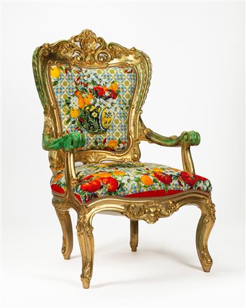 Poltrona in legno intagliato e dorato, cimasa e fascia centrate da valva di conchiglia tra volute, braccioli e piedi terminanti a ricciolo. Secolo XIX