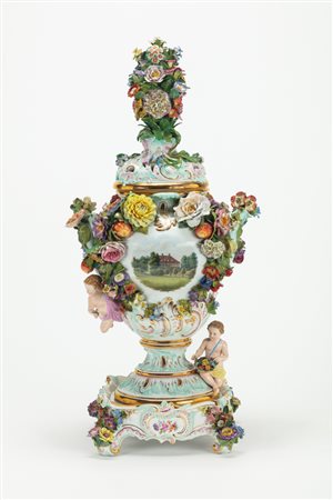 Vaso pot-pourri biansato con coperchio e base in porcellana policroma riccamente decorata a fiori, foglie, frutti e putti. Manifattura di Meissen, fine secolo XIX
