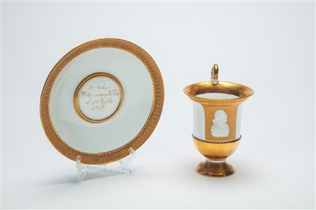 Rara tazza con piattino in porcellana bianca e in oro lucido e opaco con profilo in biscuit. Manifattura di Meissen, 1817-1818