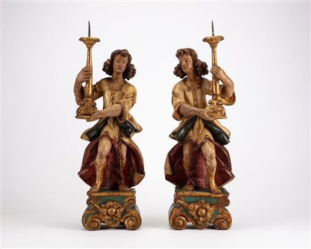 Coppia di angeli reggitorcia in legno intagliato, laccato e dorato, secolo XVII