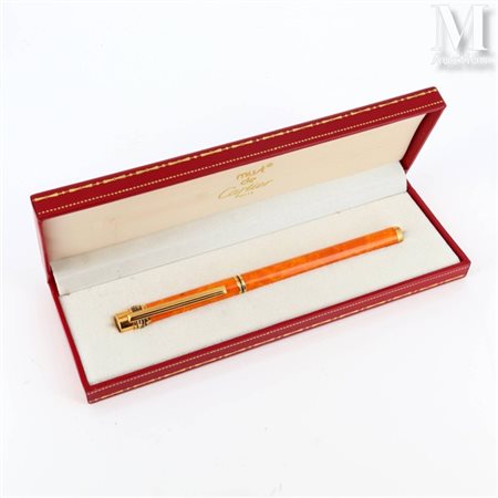 CARTIER Stylo bille Trinity en plaqué or et laque orange marbrée. Signé et...