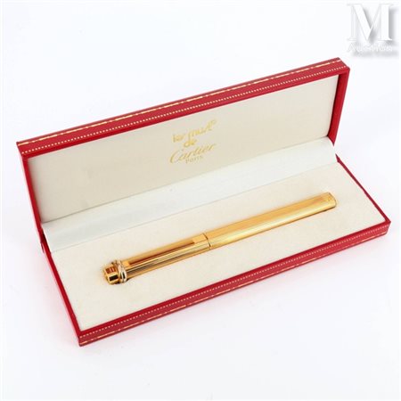 CARTIER Stylo bille Trinity en plaqué or à décor rainuré. Signé et numéroté....