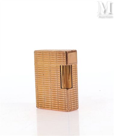 S.T. DUPONT Briquet en métal doré à décor d'un tressage. Signé et numéroté....
