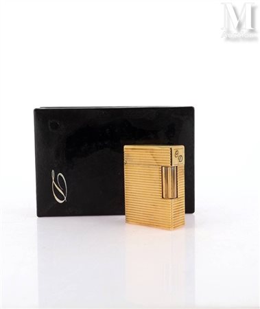 S.T. DUPONT Briquet en métal doré à décor rainuré. Monogrammée. Signé et...