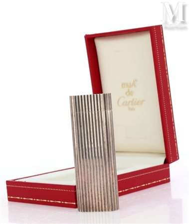 MUST DE CARTIER Briquet en métal argenté à décor rainuré. Signé et numéroté....