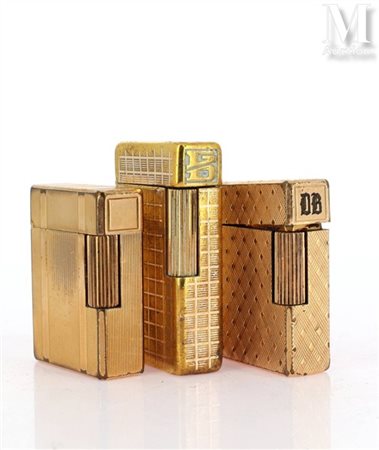 S.T. DUPONT Ensemble de trois briquets DUPONT en métal doré à décor...