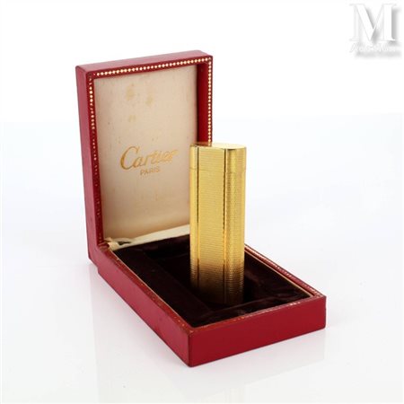 CARTIER Briquet en plaqué or en métal doré de semis. Signé et numéroté. Dans...