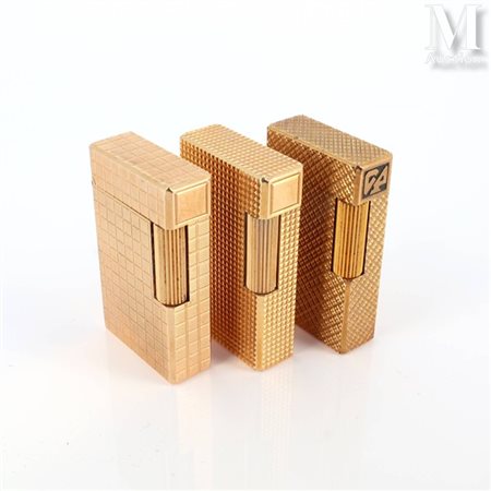 S.T. DUPONT Trois briquets Dupont en plaqué or à décor divers. Signés et...