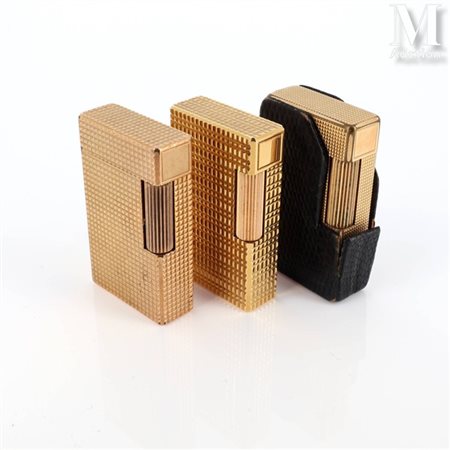 S.T. DUPONT Trois briquets Dupont en plaqué or à décor divers. Signé et...